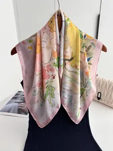 Détail d'un carré de soie à imprimé floral artistique, texture douce et couleurs vives