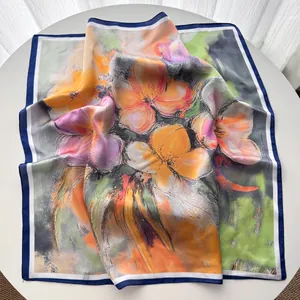 Detalle de pañuelo de seda con estampados florales artísticos y bordes acabados con esmero