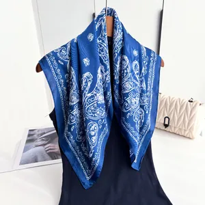 Detailed view of navy blue silk-like paisley scarf draped on a mannequin with high gloss