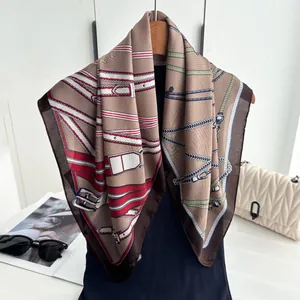 Silk-like square scarf with equestrian chain print hanging on wooden hanger with bag