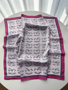 Flat lay of pink and grey silk square scarf with chic rocking horse patterns on white table