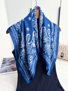 Detail of silk-like scarf with white paisley pattern draped over a wooden hanger