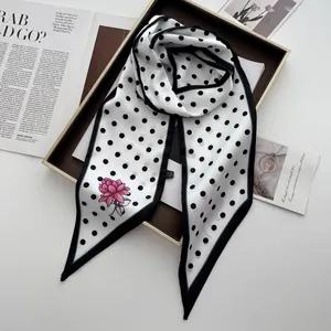 Detailansicht eines gepunkteten Seidenschals mit Blumendruck auf Displaybox und Magazin