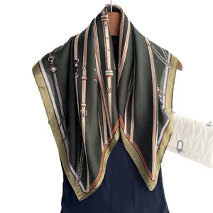 Olive green silk-feel square scarf featuring equestrian chain prints on a wooden hanger