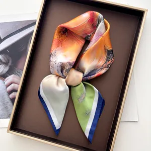 Detalle de pañuelo de seda con estampado floral de óleo y elegante lazo anudado