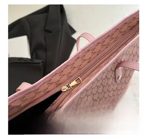 Detail shot of the smooth gold zipper closure on this pink patterned tote bag
