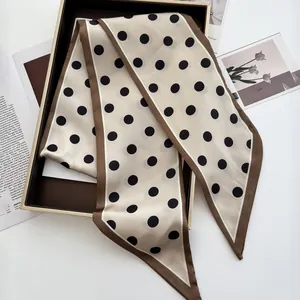 Detailed view of polka dot silk scarf with contrast edges and luxury gift box packaging