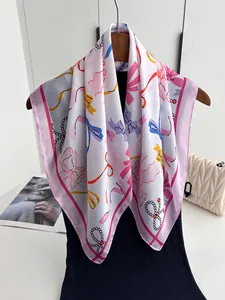 Detail eines Seiden-Halstuchs mit Schleifen- und Perlenketten-Druck auf einem Display
