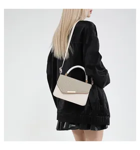 Detailed side view of linen contrast handbag with light gold hardware and rigid handle