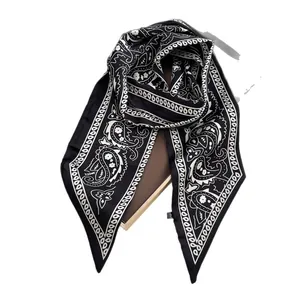 Eleganter Seidenschal mit Paisleymuster in Schwarz-Weiß auf einer Geschenkbox