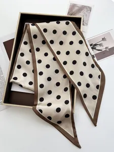 Detailed view of polka dot silk twilly scarf with elegant brown borders on a white base