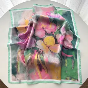 Detalle de pañuelo de seda con estampado floral al óleo y bordes en color verde menta