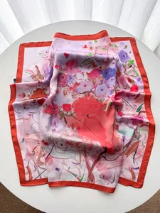 Détail d'un foulard en soie avec imprimé floral à l'huile et bordure orange vif