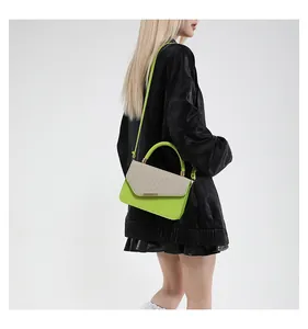 Detail of linen patchwork handbag with neon green leather handle and metallic clasp
