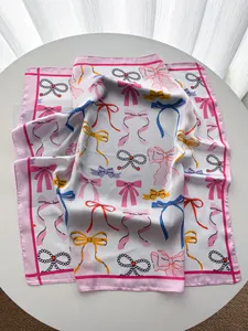 Nahaufnahme des seidigen Satin-Vierecktuchs mit rosa Rändern und eleganten Schleifen
