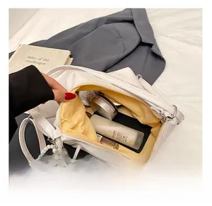 White PU leather bag showing yellow lining, internal storage capacity and pearl heart charm