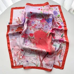 Détail du foulard en soie à fleurs roses avec bordure contrastée rouge vif élégante