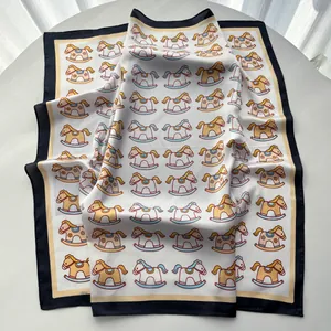 Close-up of silk scarf with vintage rocking horse prints and contrast color borders