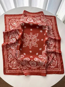 Detail of silk-satin scarf featuring intricate paisley and mandala patterns in dark brick red
