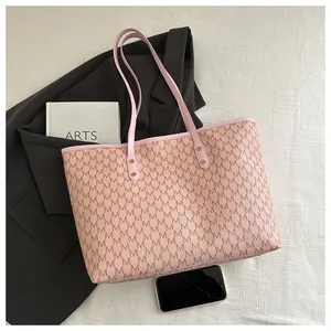 Detail of rivet-reinforced handles and M-letter print on this large pink tote bag