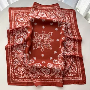 Detail of silk-like square scarf with paisley print and rich brick red fabric texture