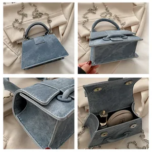 Dettagli interni della mini borsa in denim blu che mostrano il trucco e il rossetto