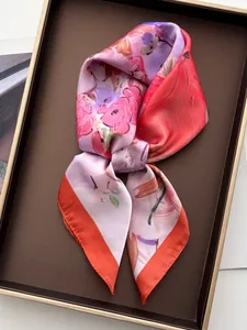 Gros plan d'un foulard en satin floral noué en nœud sur un plateau de présentation chic