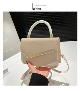 Detail of cream beige linen contrast texture handbag with white round handle and gold hardware
