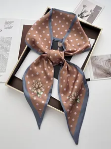 Detailansicht eines Vintage-Polka-Dot-Satinschals mit Blumenmuster in einer Geschenkbox