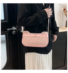 Dettaglio della borsa a tracolla rosa con fiocco elegante e trama testurizzata