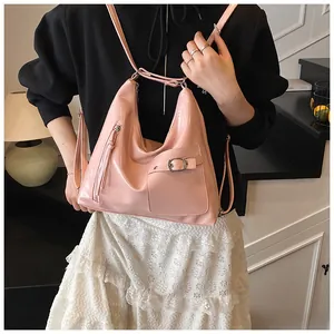 Detail of pink patent leather bag showing glossy texture and silver metallic buckle hardware