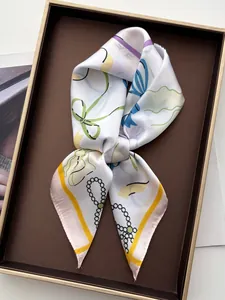 Detailaufnahme des Seidenschals mit Schleifenprint in einer edlen Geschenkbox