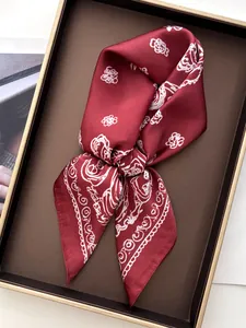 Detail of red silk scarf with white floral paisley print and elegant satin luster texture