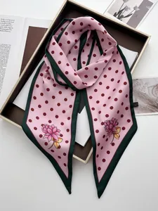 Detail eines rosa Seidenschals mit Punkten, Lotus-Print und grünem Kontrastrand