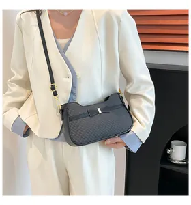 Dettaglio della borsa nera con fiocco in pelle e tessuto con eleganti chiusure dorate