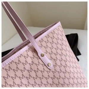 Detail of pink tote bag with M-letter print texture and golden rivet fasteners