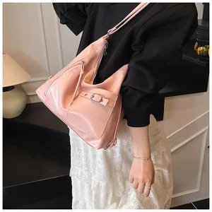Detail view of pink patent leather backpack with glossy finish and metal zipper compartments