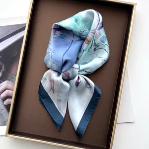 Gros plan d'un foulard en soie à motifs floraux abstraits dans une boîte cadeau brune