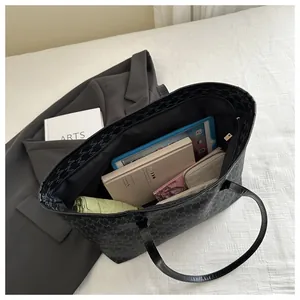 Top view of large black monogram tote bag showing spacious interior with daily essentials