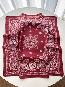 Macro shot of paisley print silk scarf in deep red featuring detailed mandala patterns