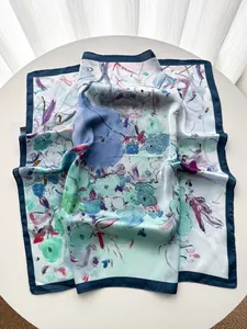 Vue détaillée du motif floral de peinture à l'huile sur le foulard en soie avec bordure bleue