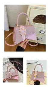 Détail du sac bandoulière rose avec texture tissée, rabat et fermoir fleur dorée