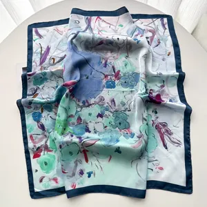 Détail d'un foulard en soie à fleurs bleu et violet avec un ourlet bleu marine chic