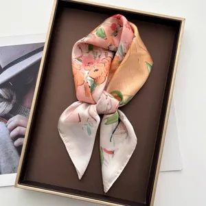 Détail d'un foulard en soie à imprimé fleuri satiné dans son coffret cadeau