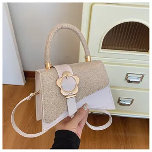 Détail du sac bandoulière tendance avec rabat tissé, fermoir doré et fond de parquet