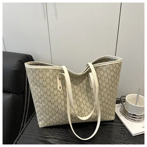 Detailed view of large tote bag with vintage letter print and gold rivet hardware