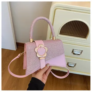 Détail du tissu pailleté rose et du cuir lisse avec fermoir en pétale doré