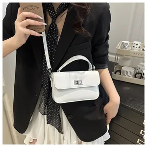 White minimalist square handbag with silver twist lock shown on model with shoulder strap