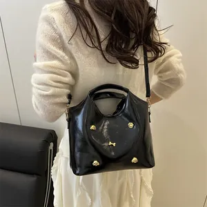 Retro black high-gloss tote with gold dog-themed hardware and adjustable strap