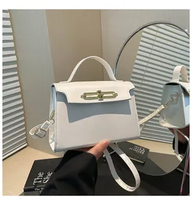 Detalle de bolso de cuero blanco con cierre de metal dorado y textura suave